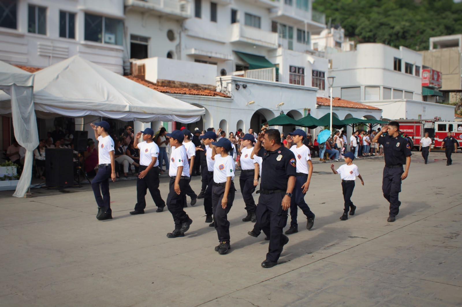 Integrantes del Grupo Juvenil realizando el saludo al pasar frente al presídium