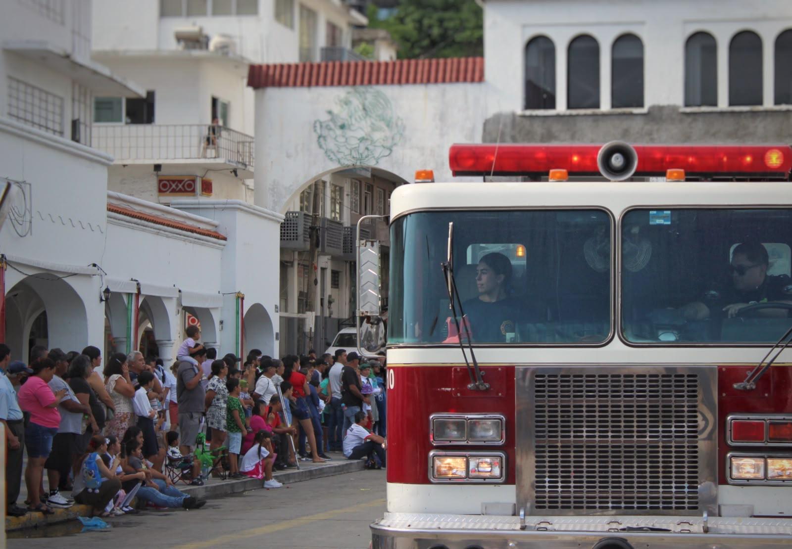 Unidad de bomberos avanzando frente al público en el centro de Manzanillo